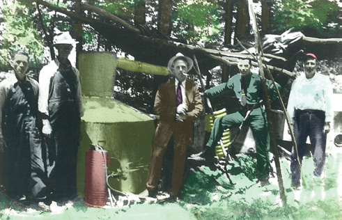 E. Y. Ponder (center) and his men posing with a backwoods moonshine still Courtesy of Pat Franklin